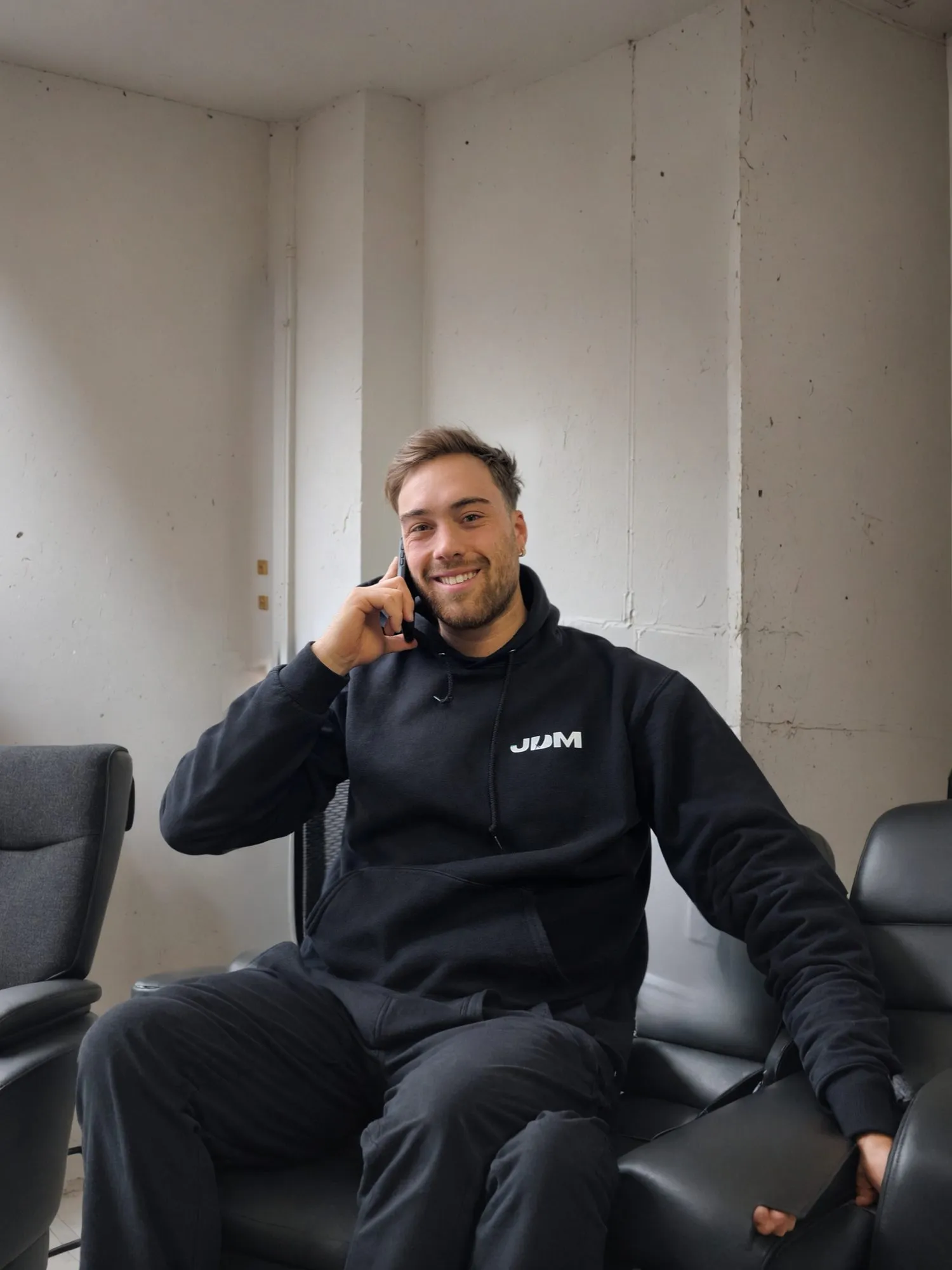 A Lavage JDM team member speaks with a customer by phone beside the company truck.