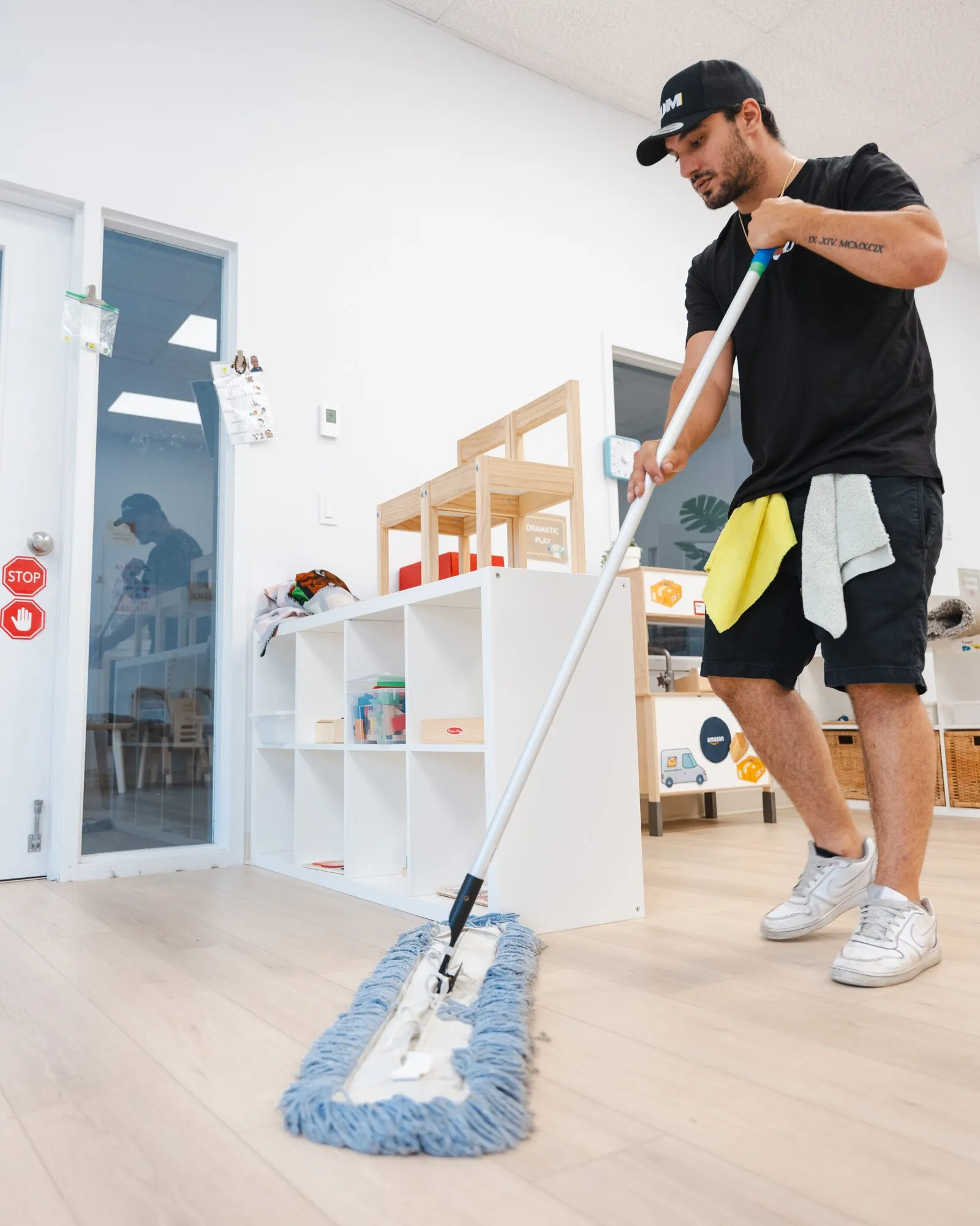 A Lavage JDM technician mops the floor of a bright commercial space.